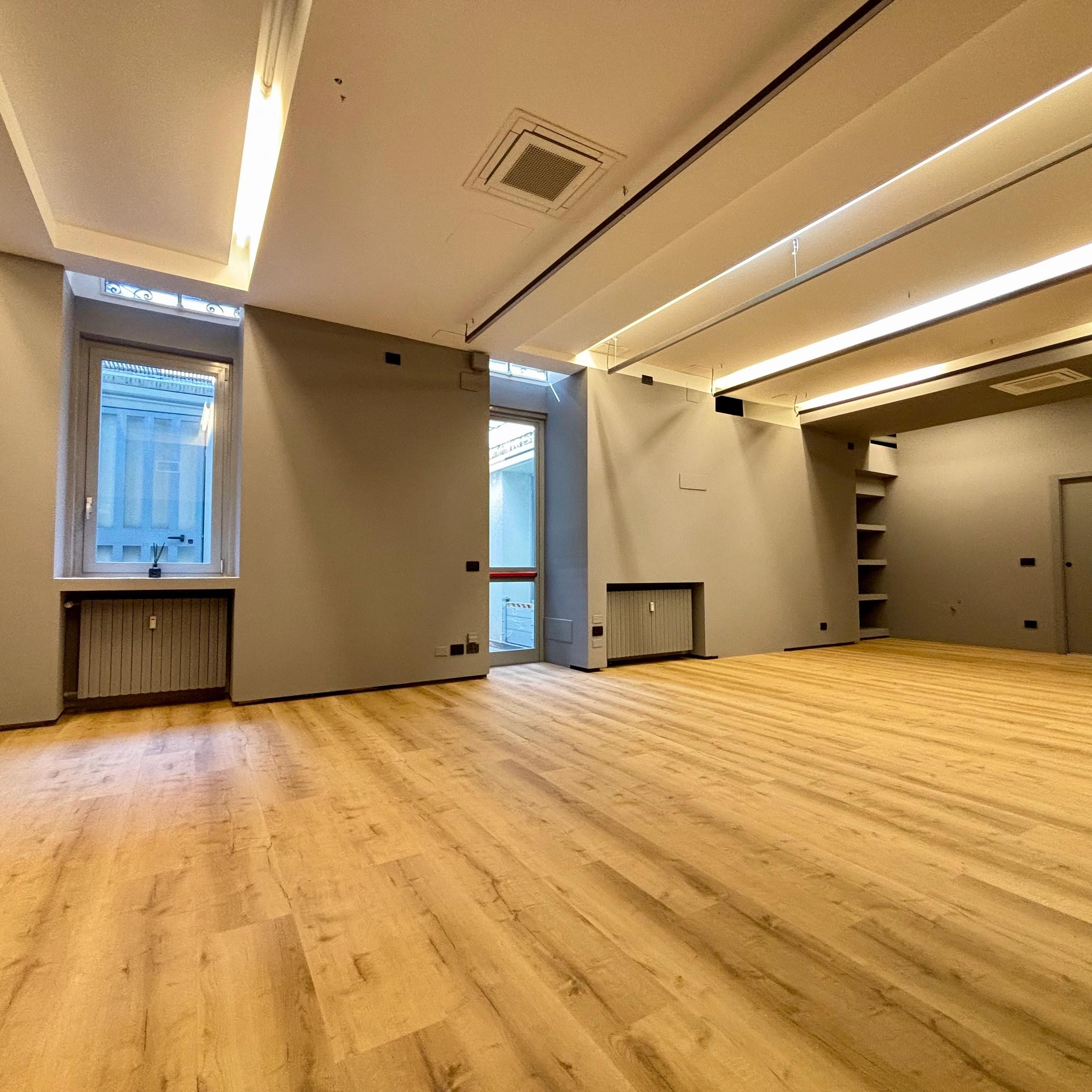 windowed open space office with wooden floor
