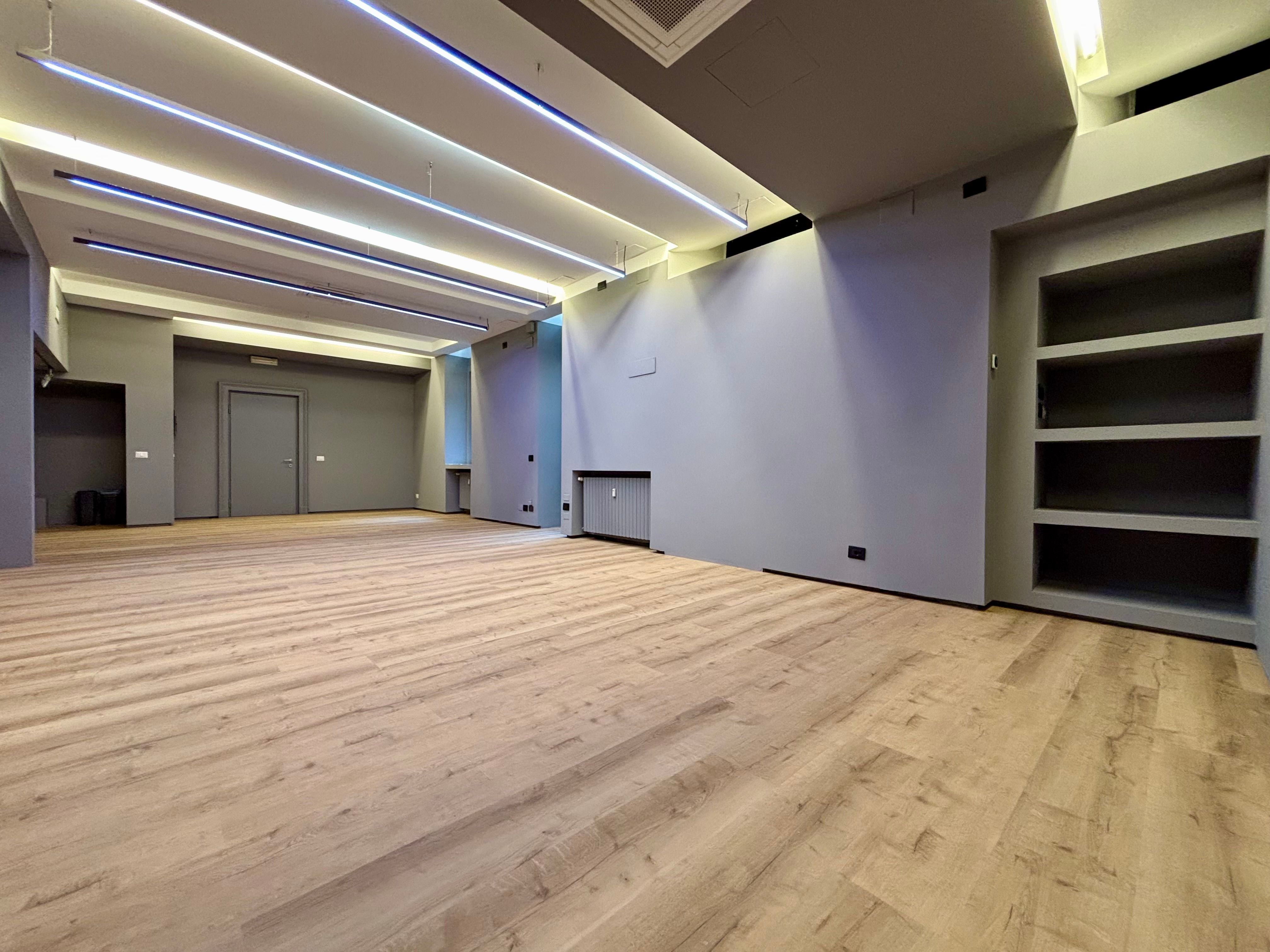 Open space office with wooden floor, library and heaters
