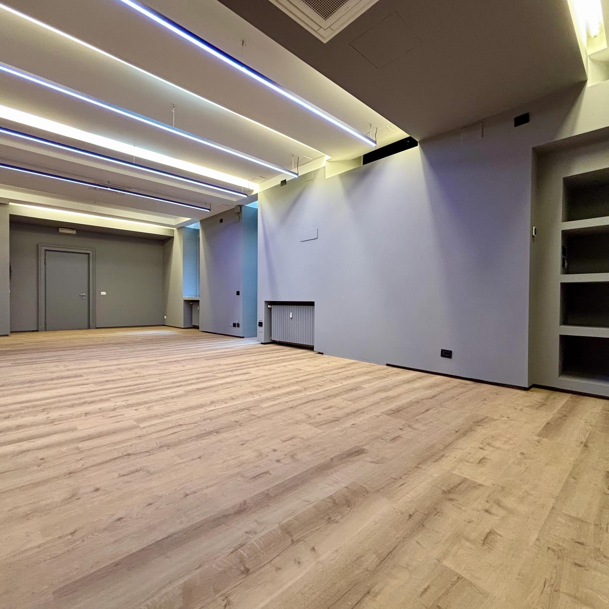 Open space office with wooden floor, library and heaters