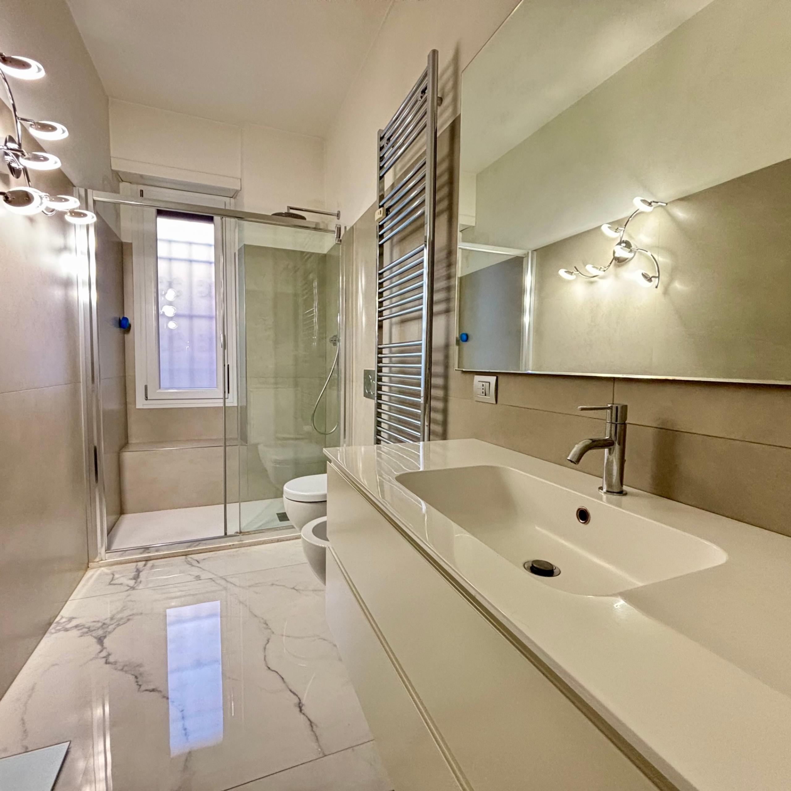 bagno con finestra, lavandino e doccia