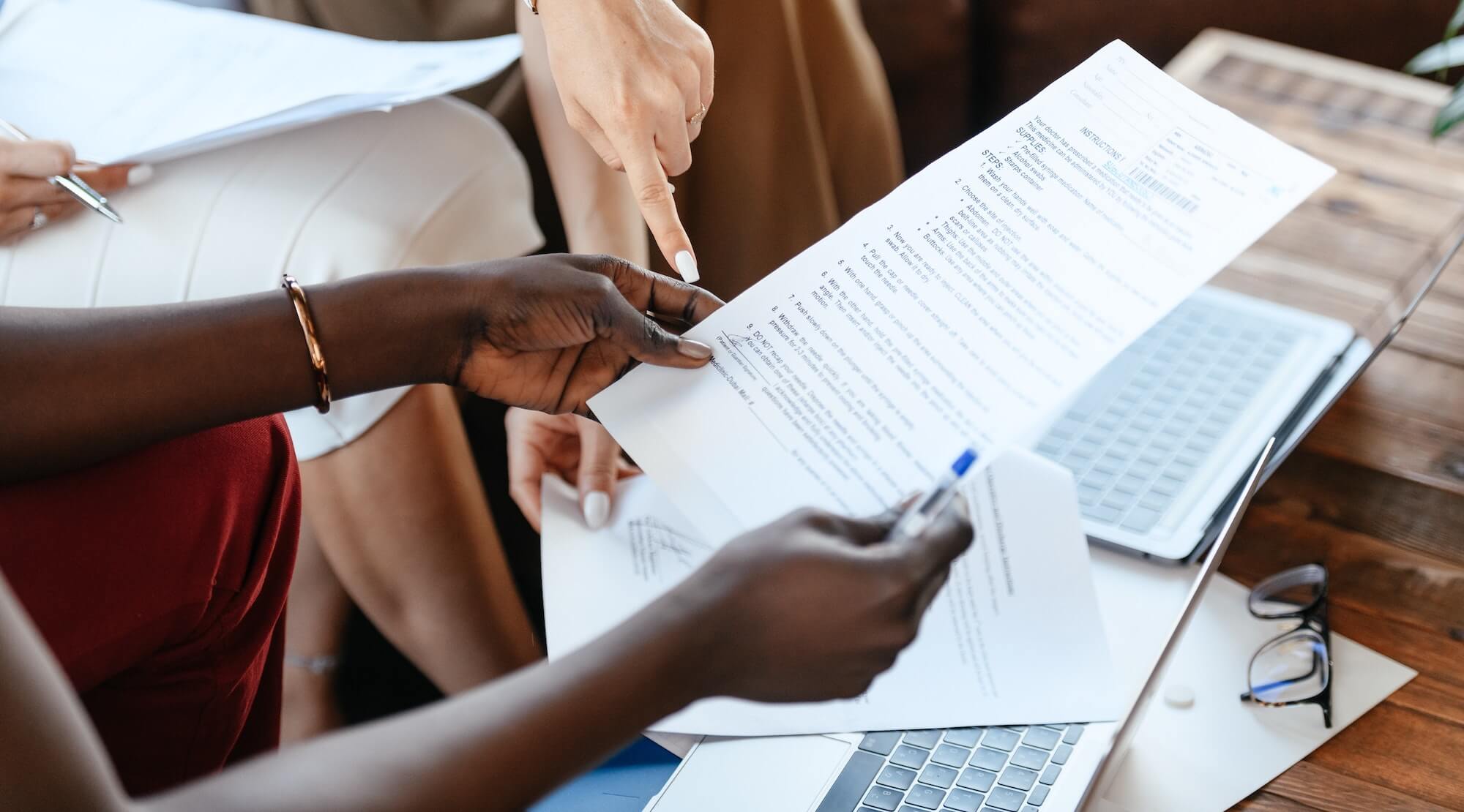 Closeup of two people working through set of instructions reviewing paperwork