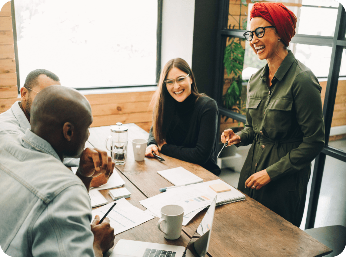 Photograph showcasing a collaborative team smiling during a meeting.