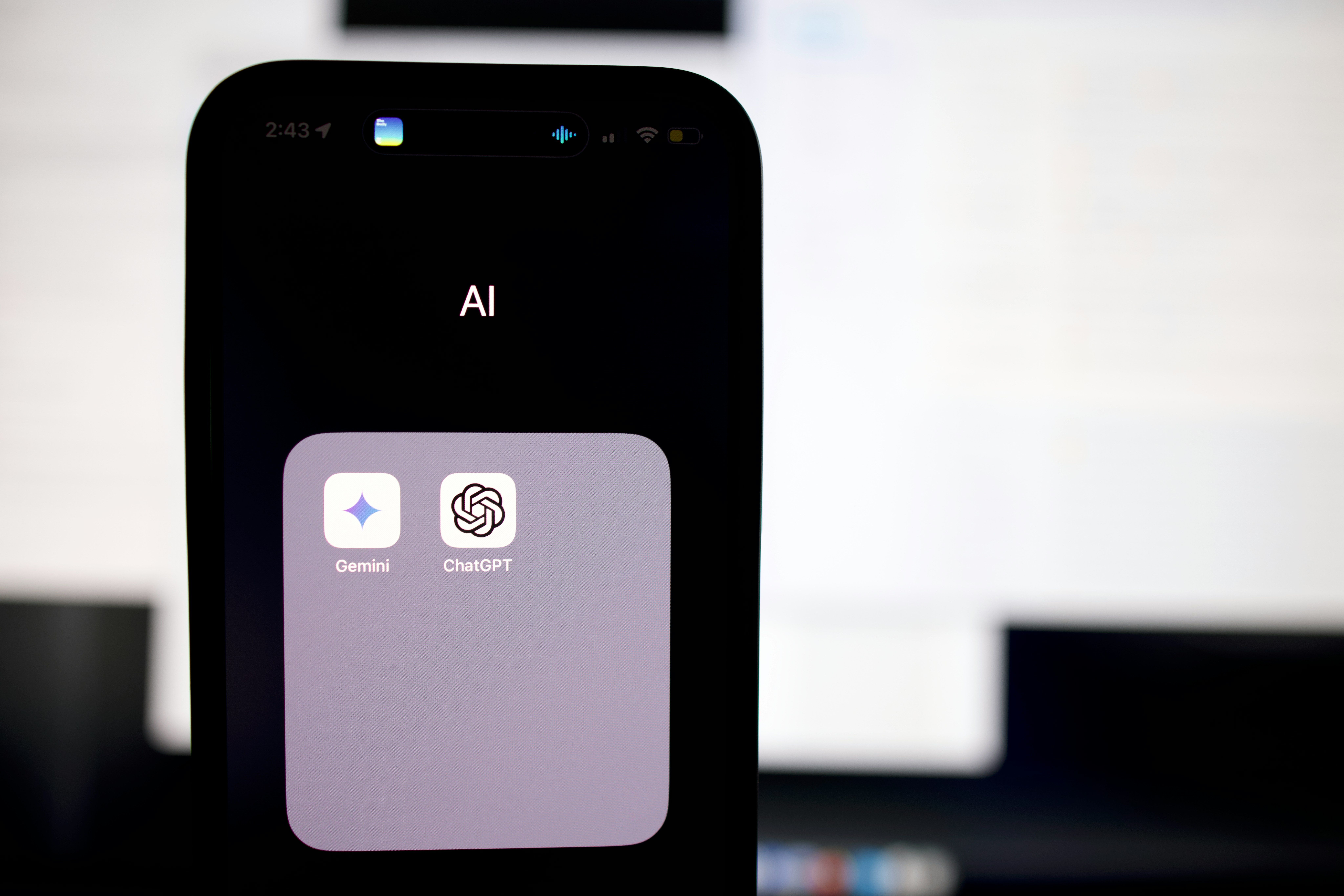 A photo of a smart phone with the Gemini and ChatGPT apps visible.