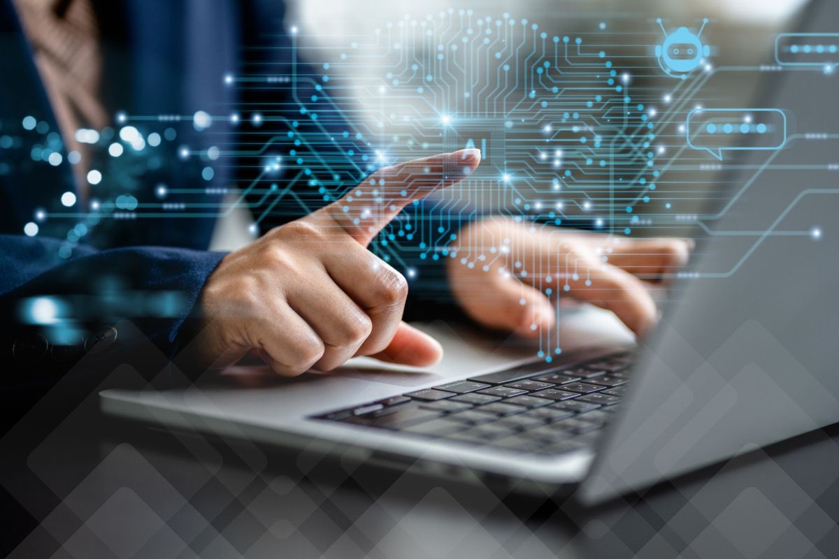 Hands using a laptop with an overlay of digital circuits forming a brain shape and a chatbot icon.