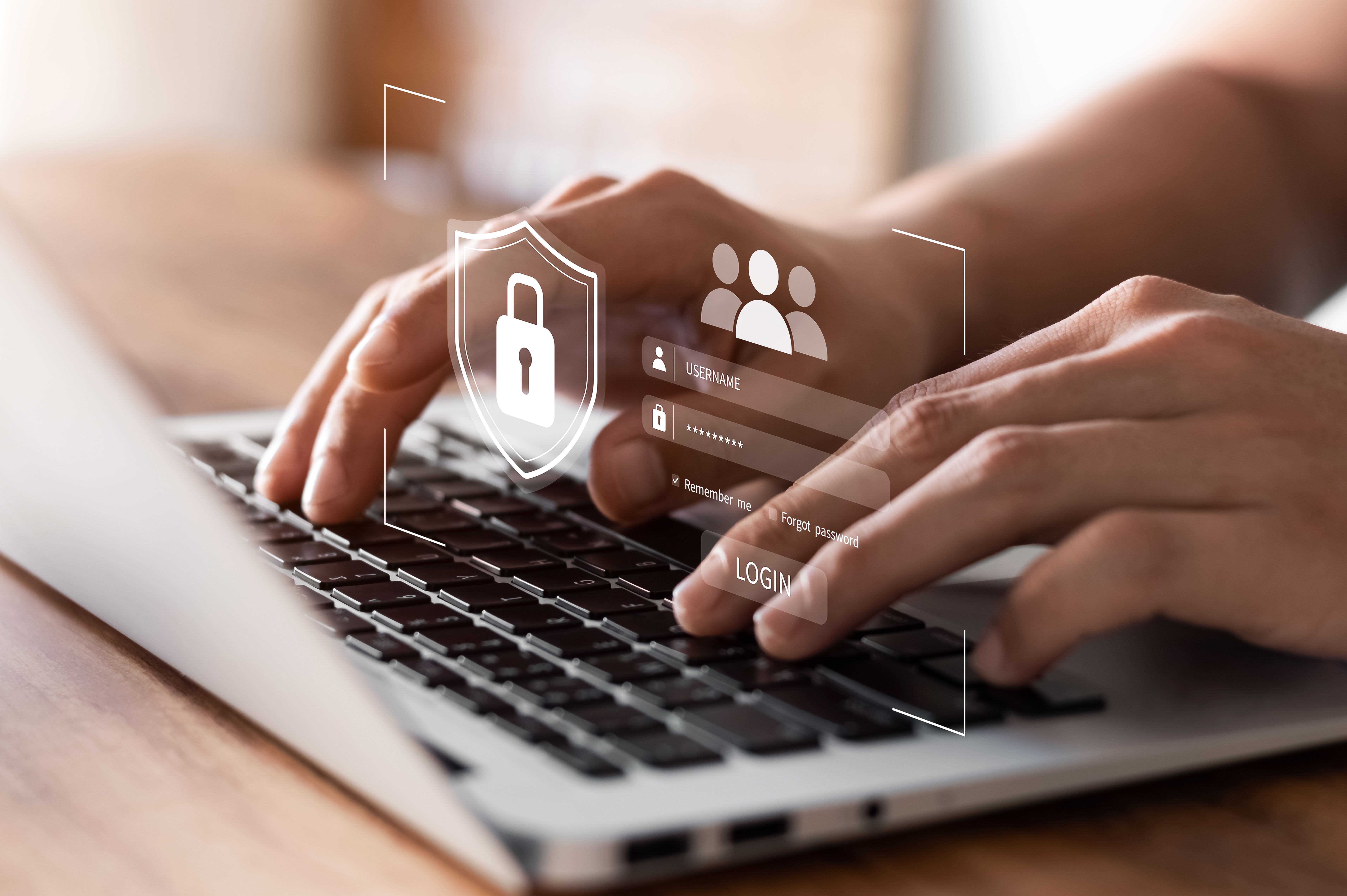 Hands typing on a laptop keyboard with overlay graphics of a shield icon and login fields, symbolizing online security.