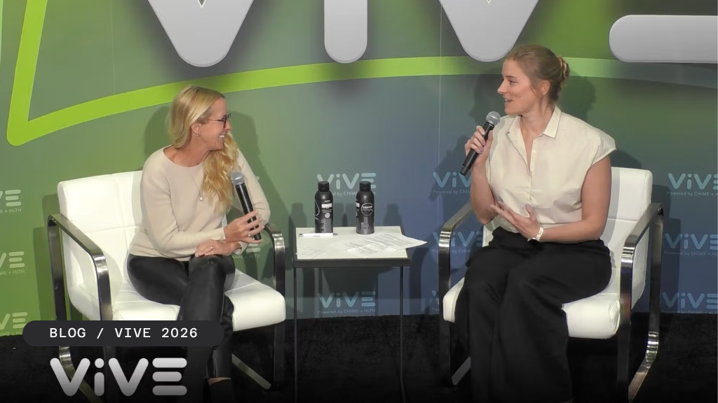 Two women sit in chairs, holding microphones, engaged in a panel discussion at a VIVE 2026 event.