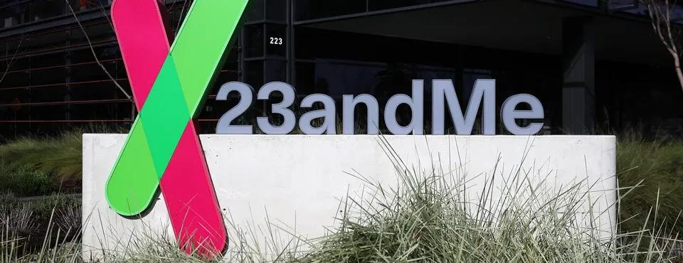 The image depicts the 23andMe logo outside a building, featuring large, colorful letters in a landscaped environment.