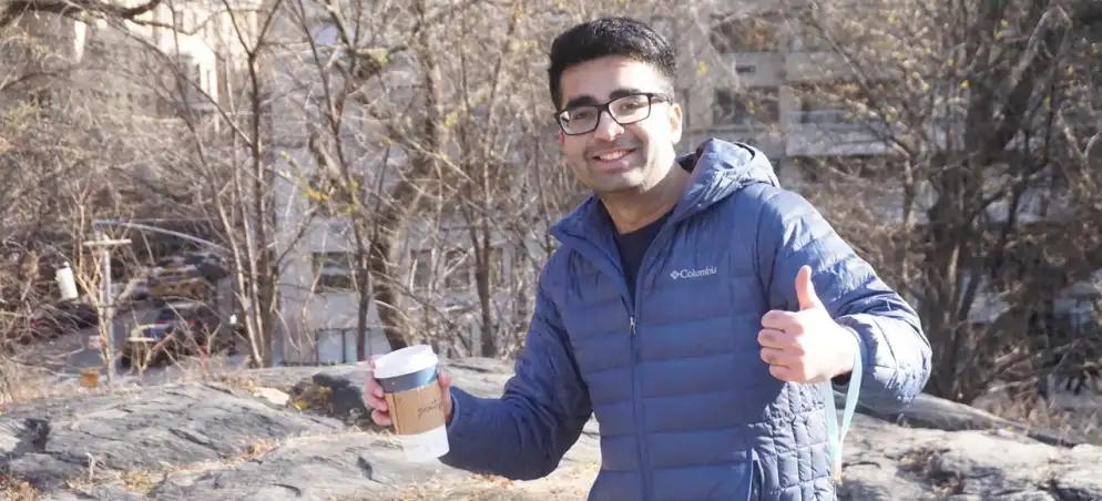 Dipack Panjabi giving a thumbs up while holding coffee