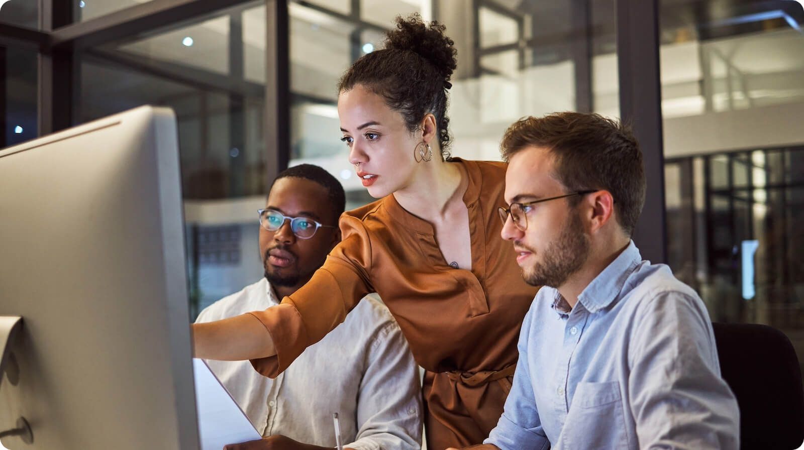 Three professionals sitting around computer working in a consent management platform