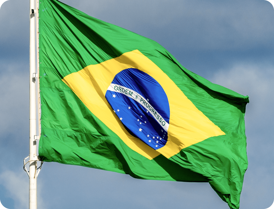 Brazilian flag in front of a cloudy sky