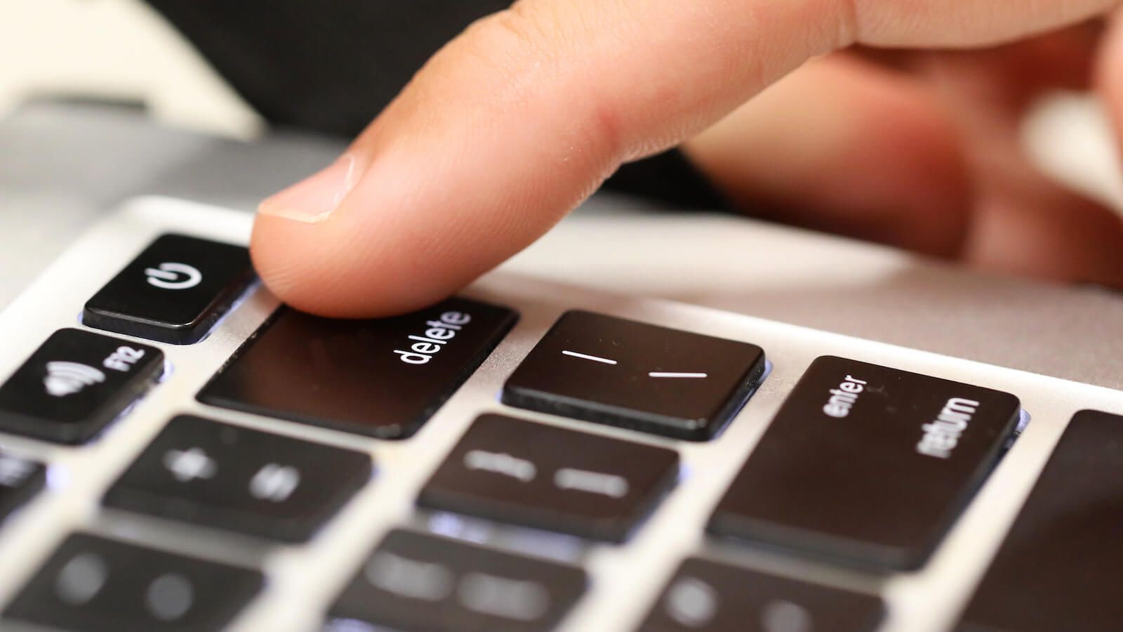 Hyper close up of finger pressing the delete key on keyboard