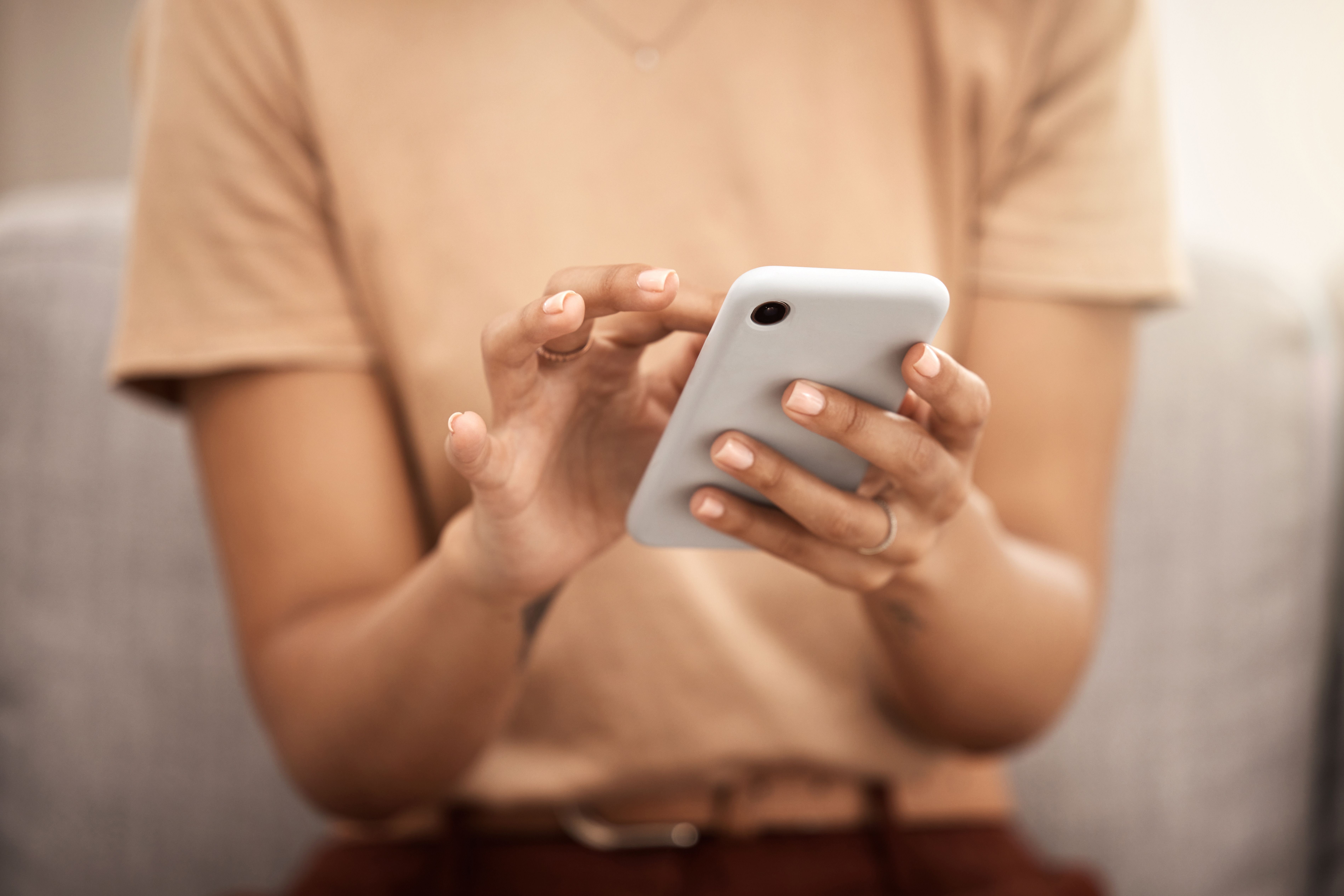 Hands using a white smartphone.