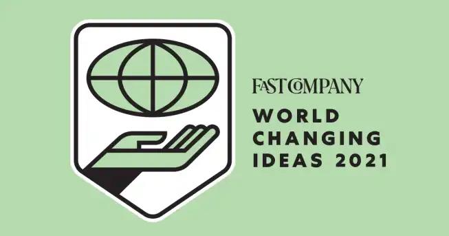 Light green background with globe over hand logo design and text reading fast company world changing ideas 2021