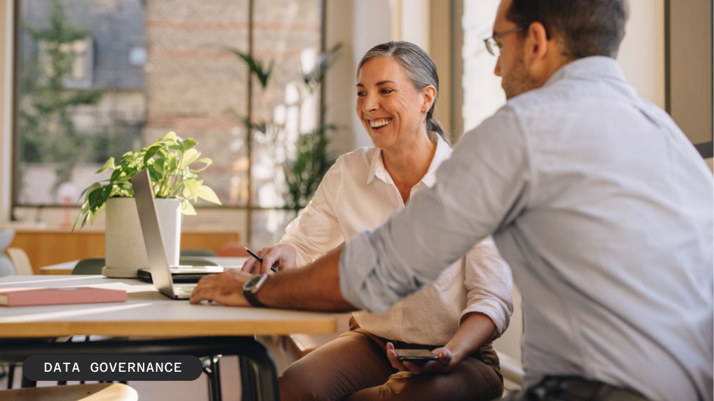 Two smiling people collaborating on a laptop with "BLOG / DATA GOVERNANCE" text overlay.