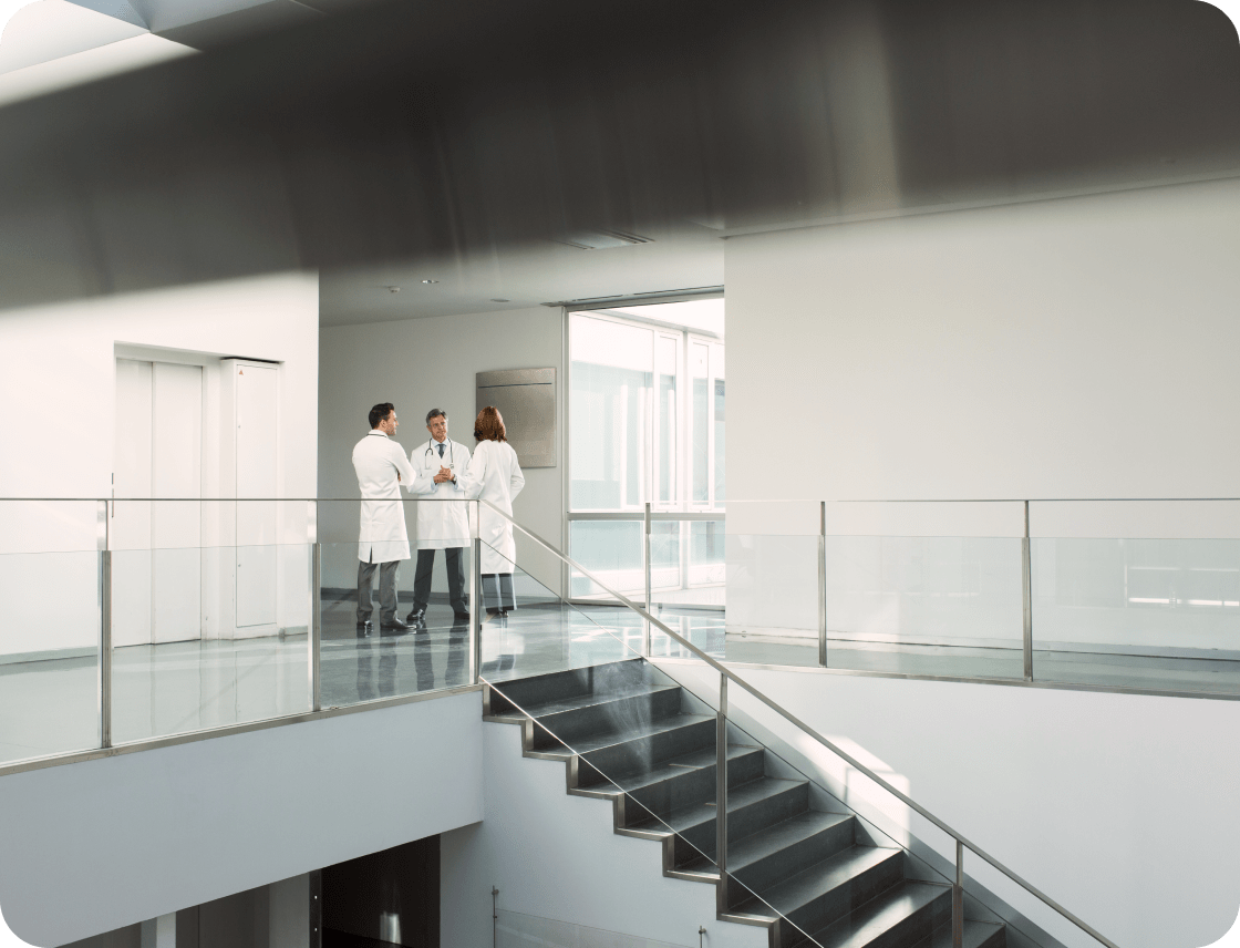 Three doctors discussing in a modern hospital setting
