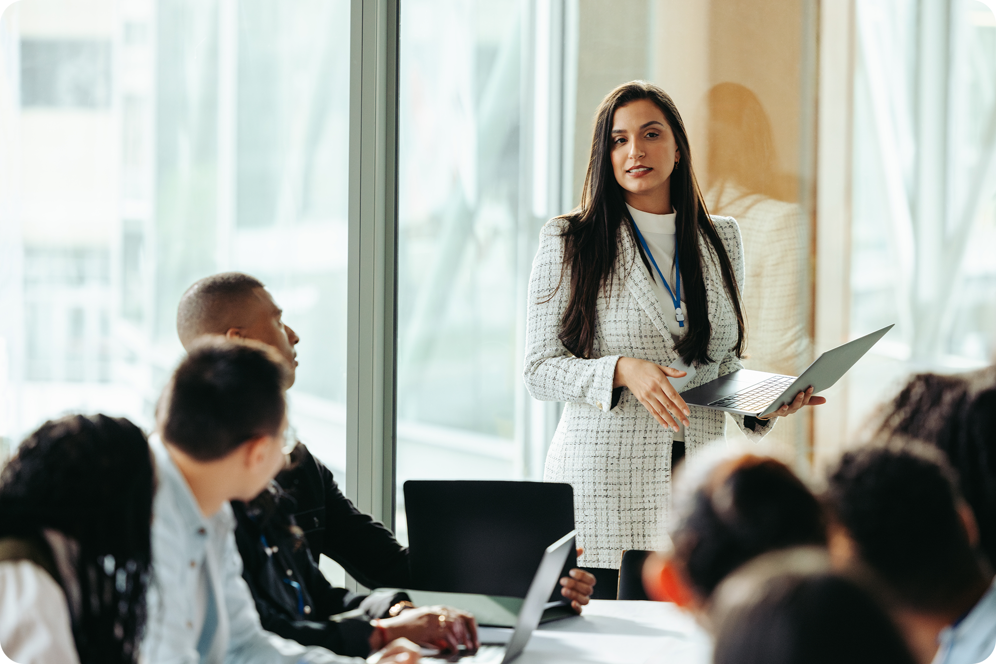 Business woman leading a packed meeting in a conference room