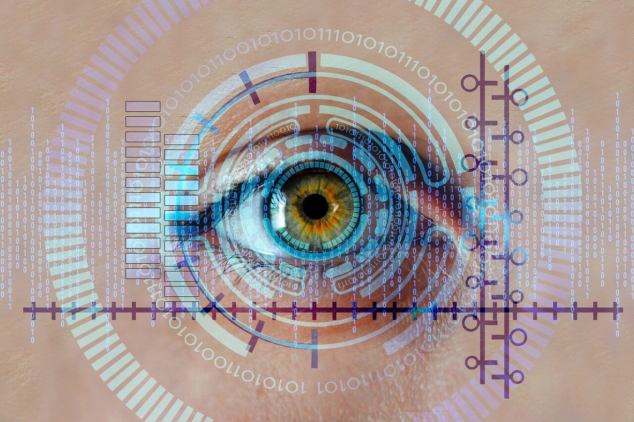 Closeup of an eye with graphics overlayed showing binary code and circular rings