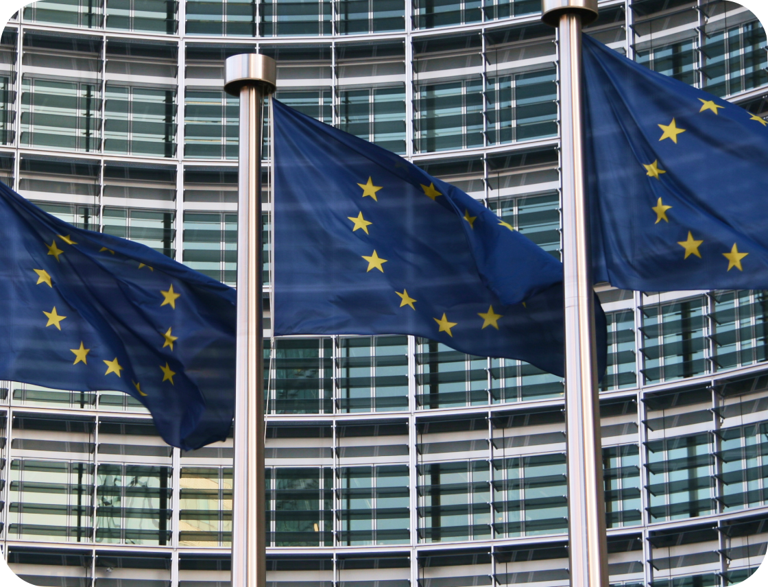 Three EU flags waving in front of modern building