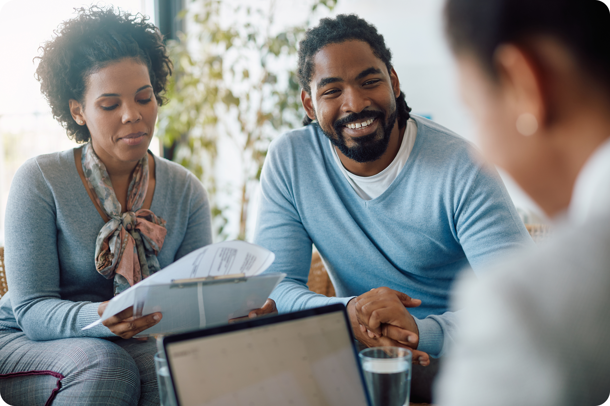 Couple talking to an insurance agent and looking at paperwork