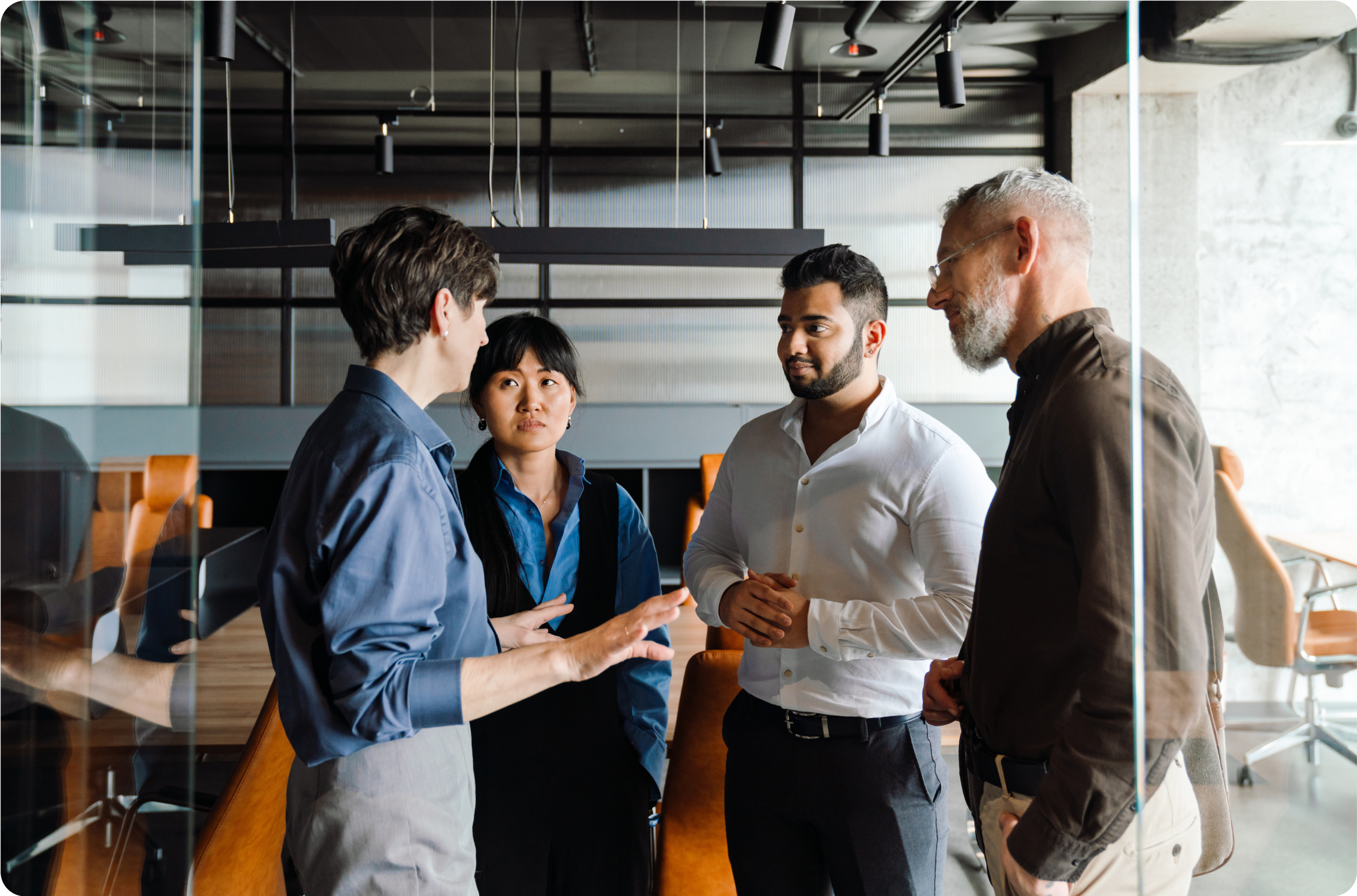 Four professionals standing in a circle talking