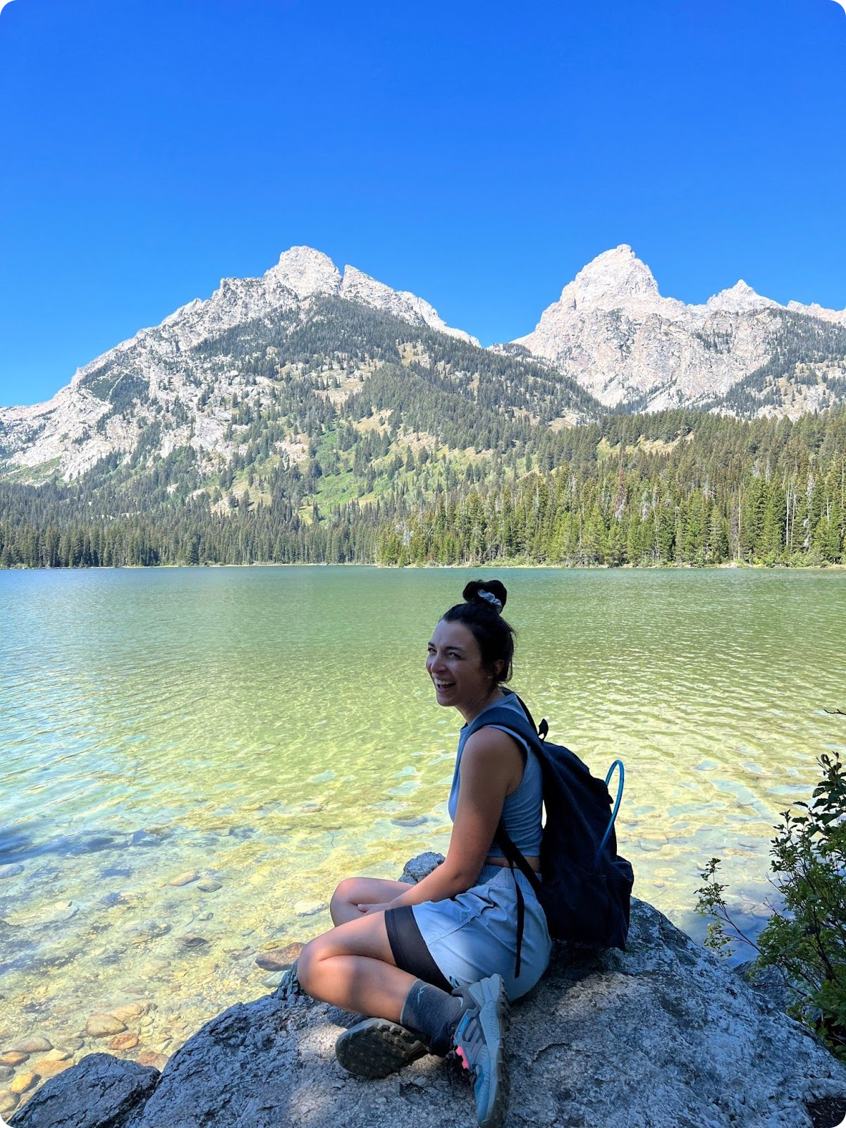 Jess Bronowicki, Head of Sales Engineering at Transcend, sitting beside a beautiful mountain lake