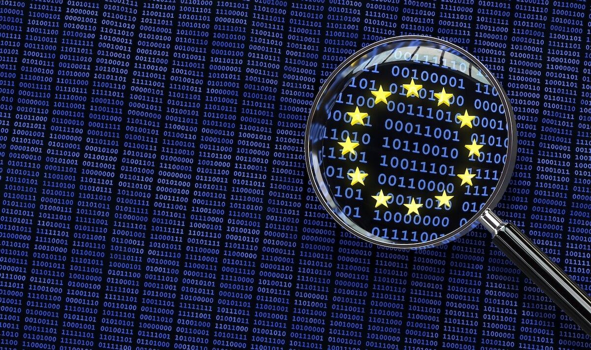 Magnifying glass viewing closeup of the EU flag made up of binary code