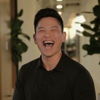 A photograph of Brandon Chen. In the photo, he is laughing with a wide smile.
