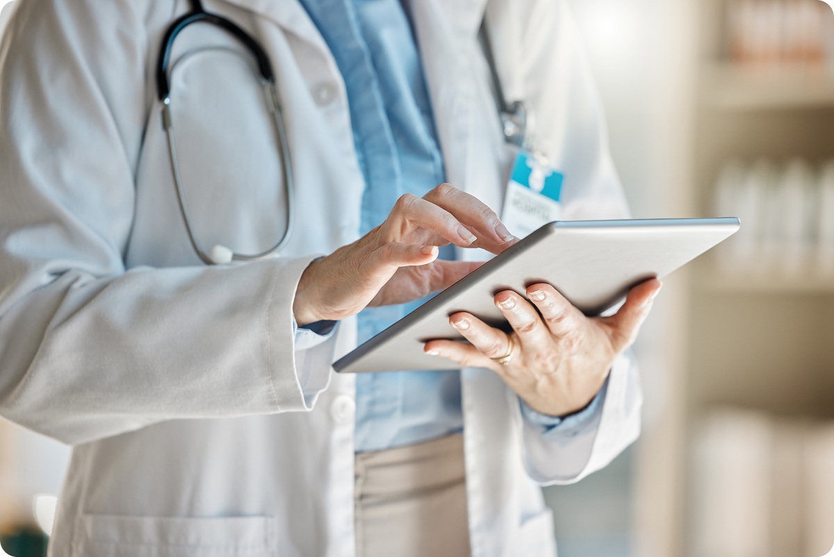 A snapshot of a doctor's hands using an iPad to input a patient's health data