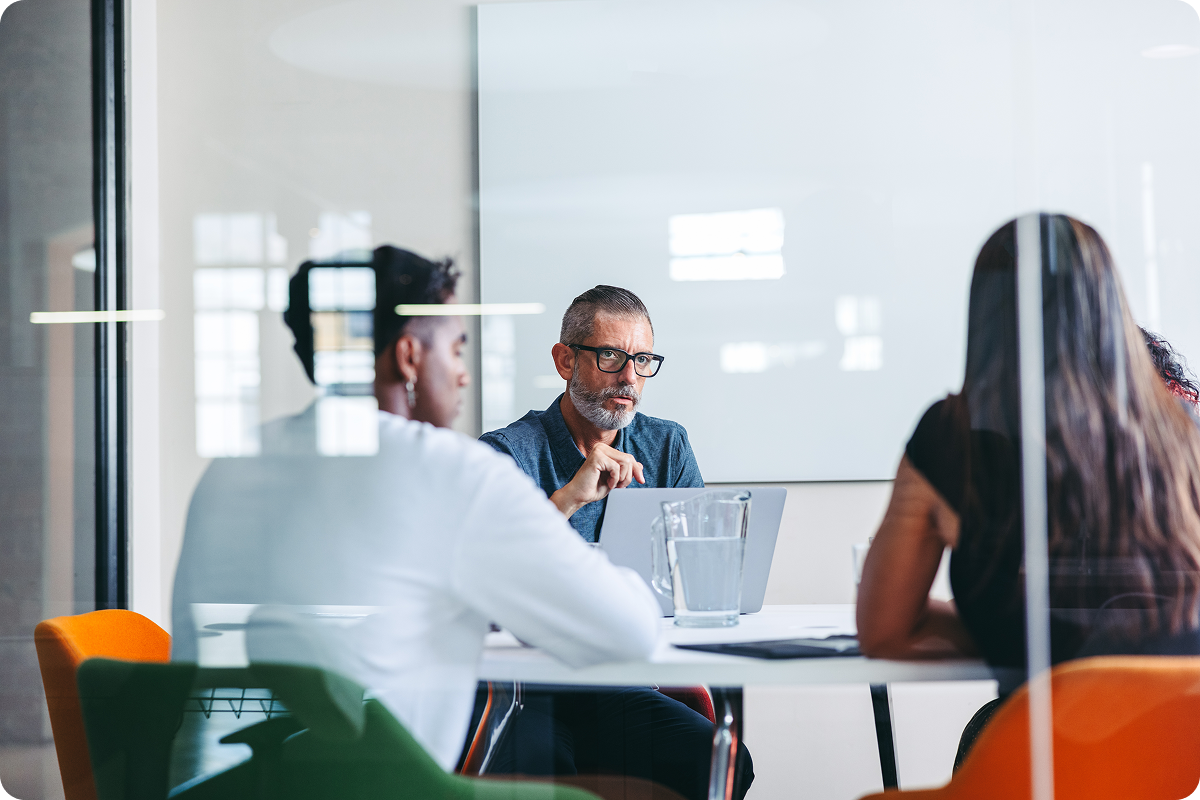 Three people sitting in a conference room talking