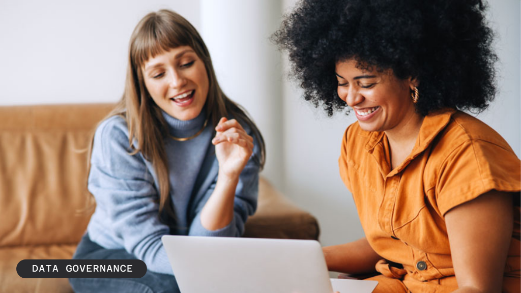 Two smiling women look at a laptop, with text "BLOG / DATA GOVERNANCE" overlaid.