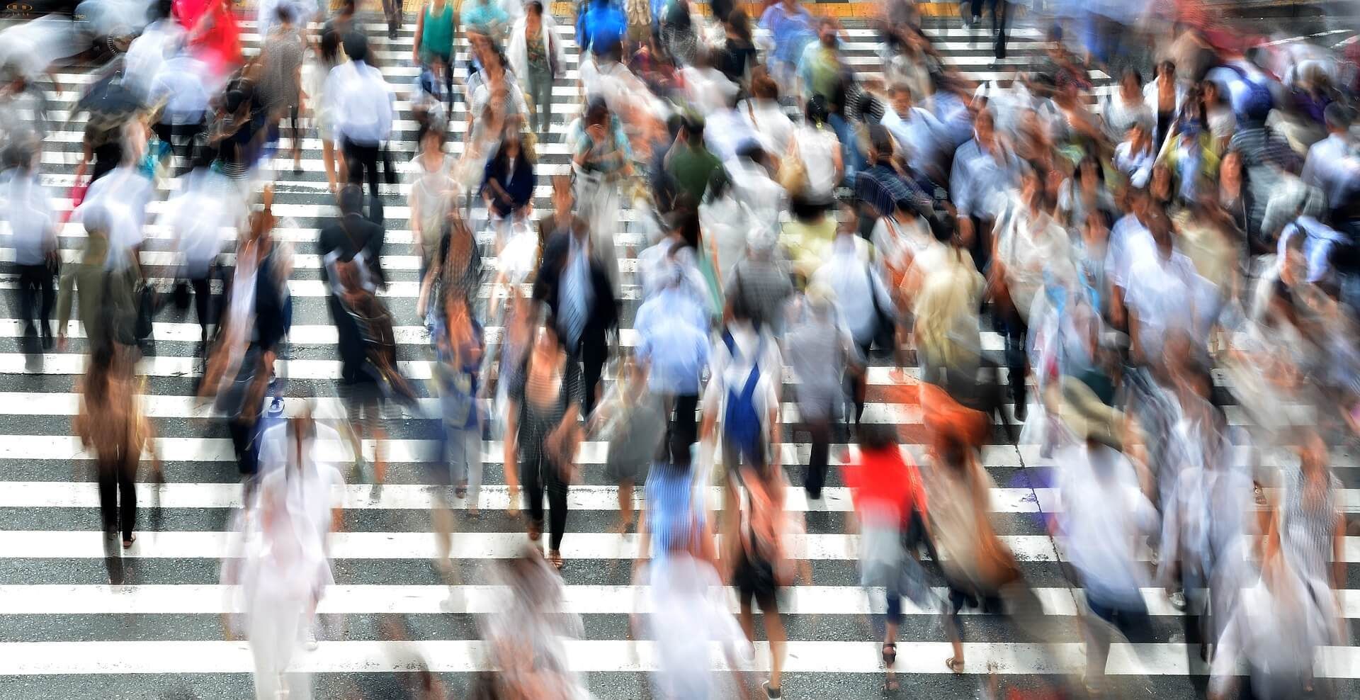 Blurred view of busy city walkway with pedestrians