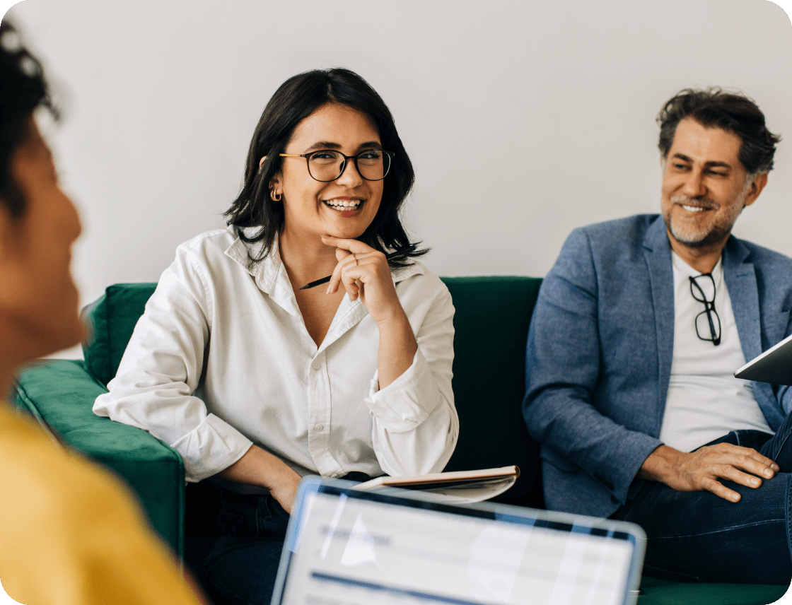 Photograph of woman smiling at her coworker in a meeting.