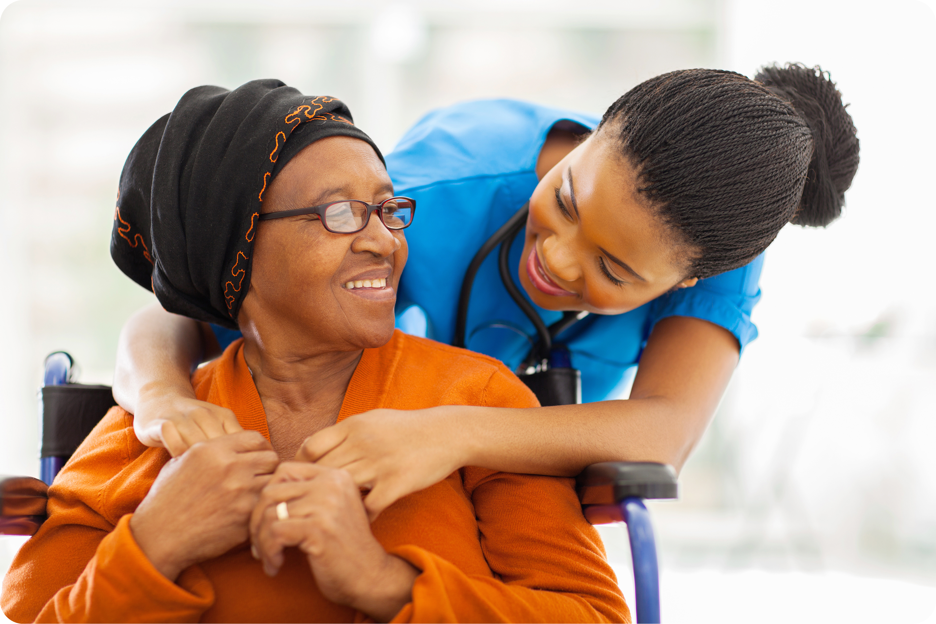 A medical attendant and patient hugging and smiling