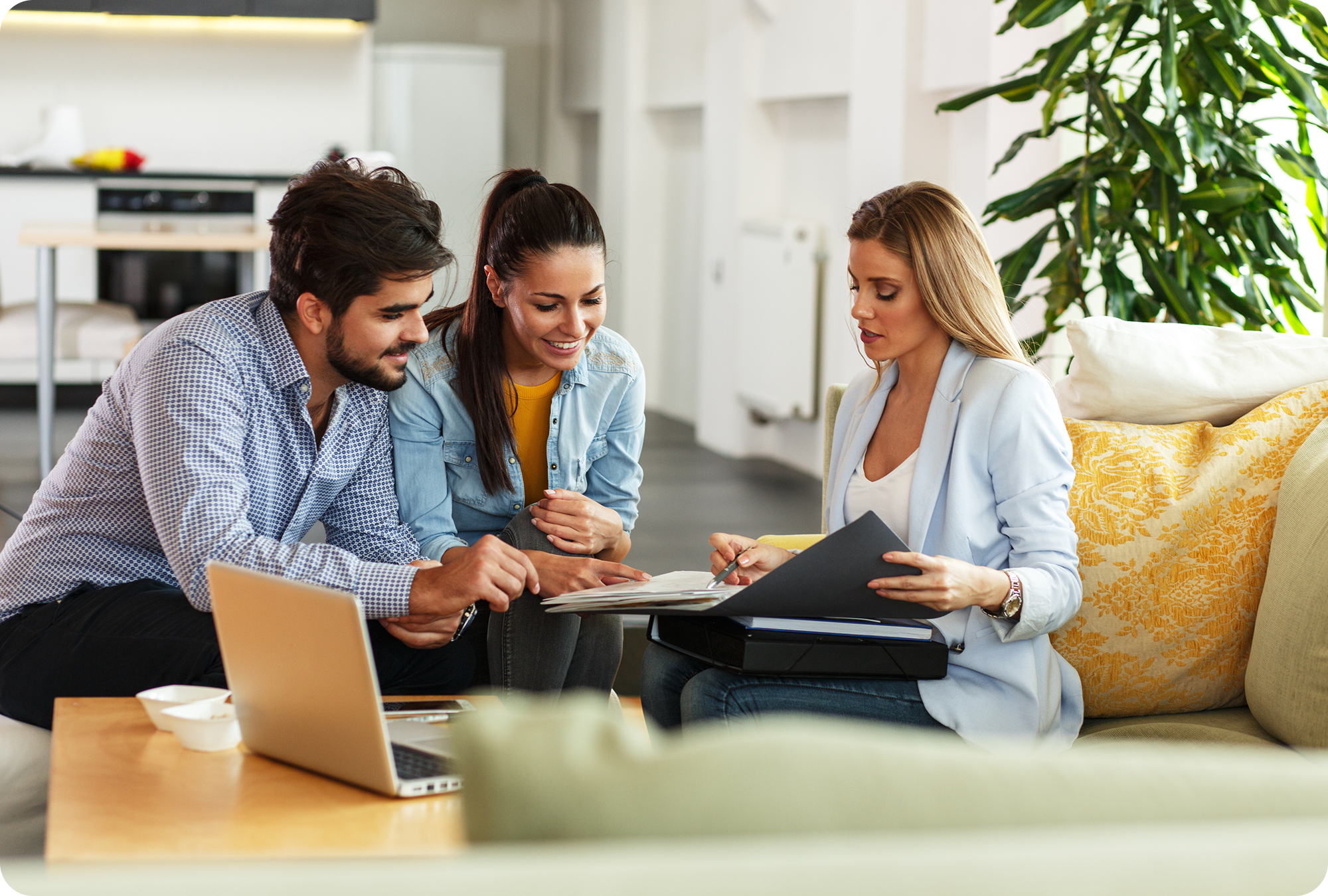 Young couple speaking with an insurance agent while looking at contract papers