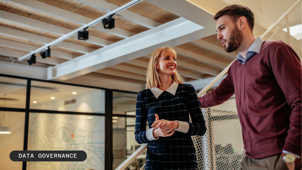 Two smiling colleagues talking in a modern office with "BLOG / DATA GOVERNANCE" text.
