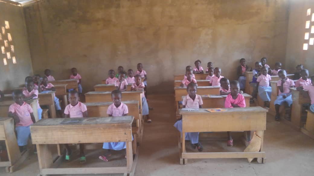 Une salle de classe de l’école Parisel, les élèves en uniforme rose assis à leurs pupitres.