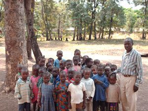 Un groupe d’enfants réunis sous les arbres avec un adulte, lors du voyage de 2008.