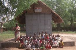 Les élèves assis devant le wagon rénové de l’école de Bangui, sous son toit de paille, en 2004.