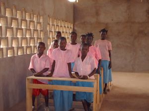 Des élèves en blouse rose à leurs pupitres, dans une salle de classe, en 2010.