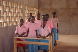 Des élèves en blouse rose à leurs pupitres, dans une salle de classe, en 2010.