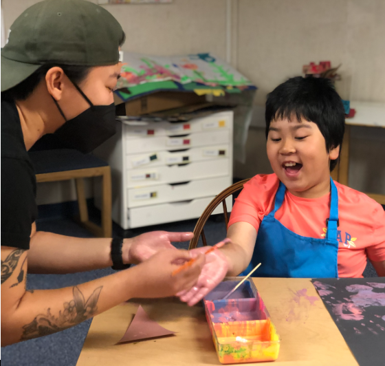 Adult and child engaged in art activity at Creekside School