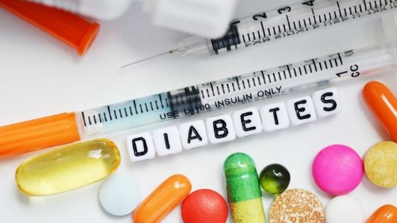Insulin needles, pills, and the word "Diabetes" in blocks