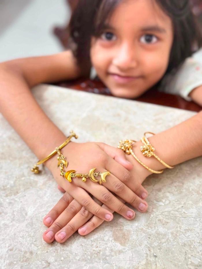 The Crescent Moon Hand Chain, styled with bangles