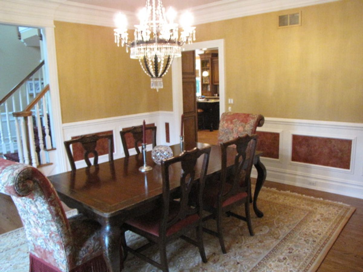 Dining room with sponge-painted walls in deep red above white wainscoting — by Joanna Kruza, Nyack NY