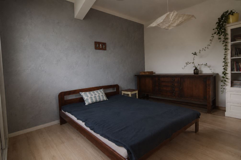 Microcement on a bedroom wall — seamless matte surface