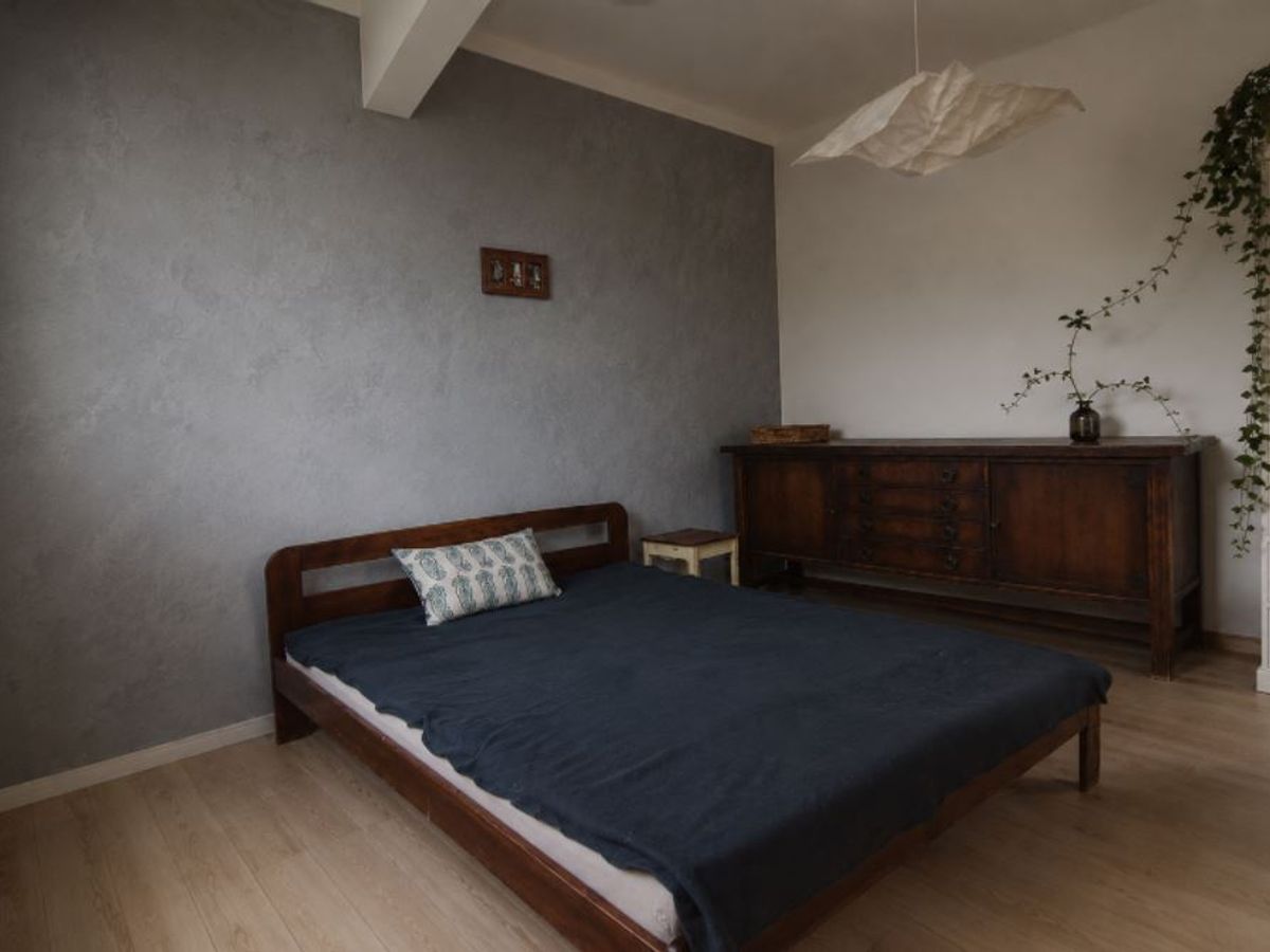 Microcement on a bedroom wall — seamless matte surface
