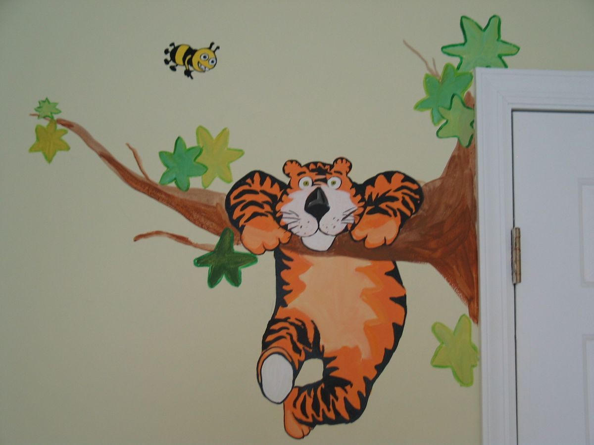 Close-up of a mural with a tiger cub on a branch among colourful leaves