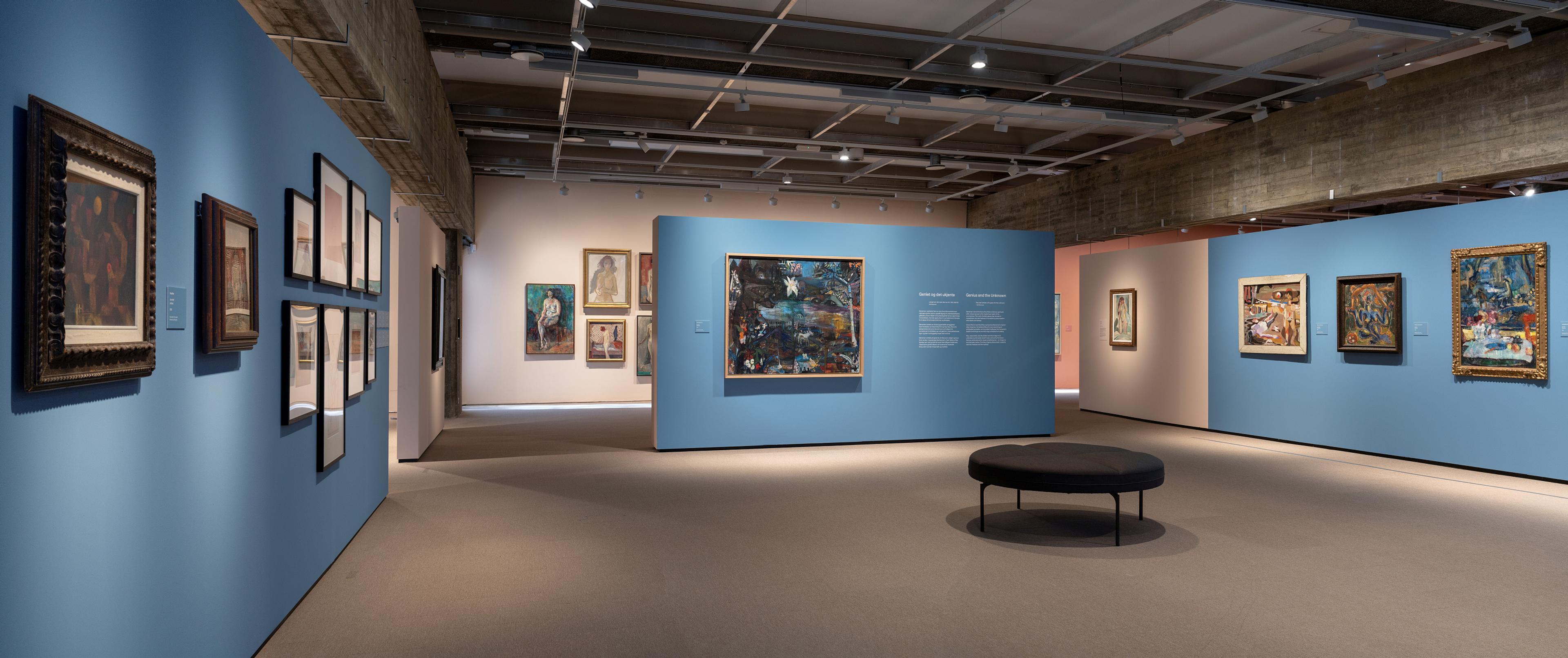 En utstillingssal med blåmalte vegger og en rekke malerier