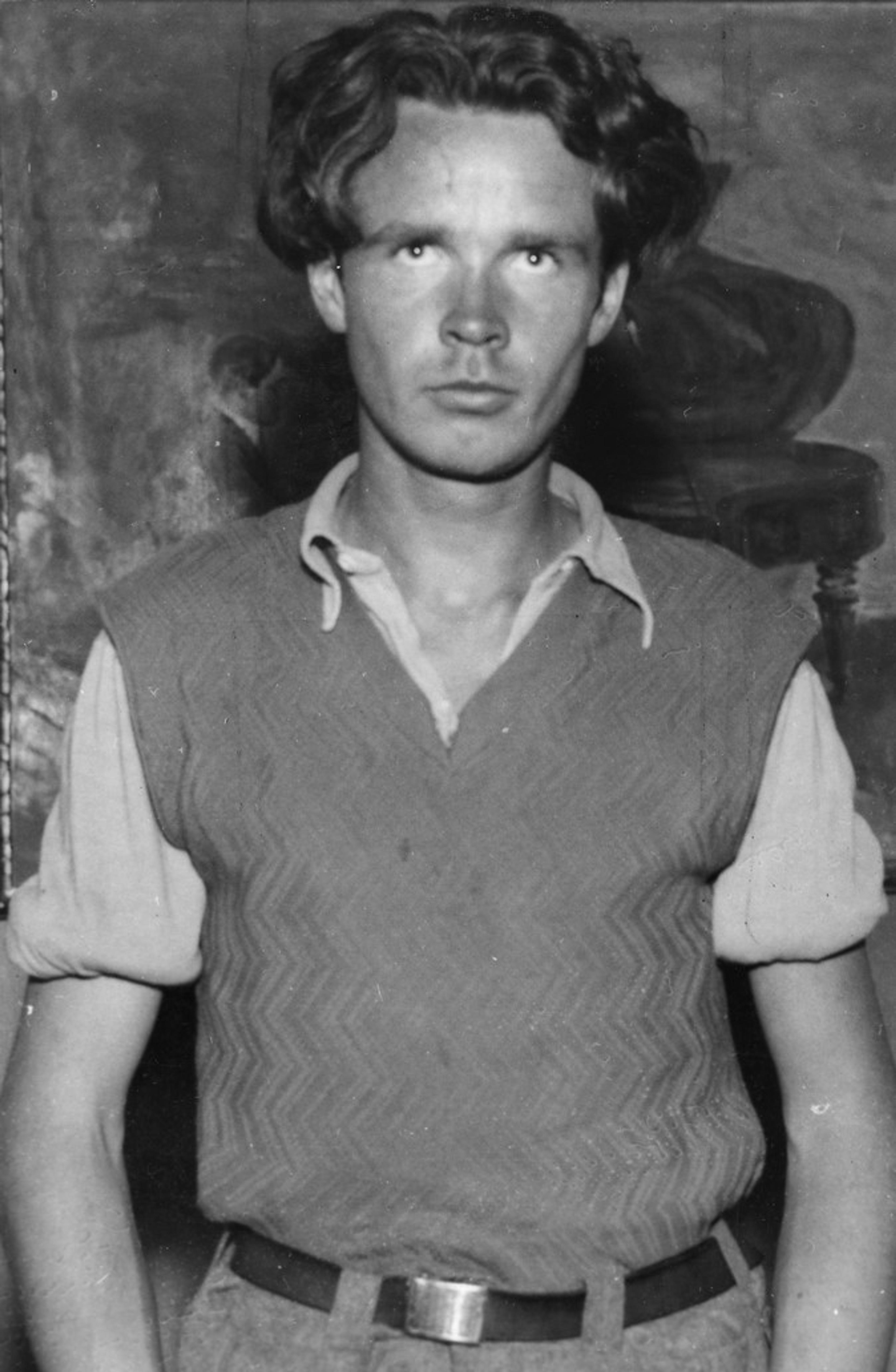 Sort-hvitt foto av en mann kledd i strikket vest.