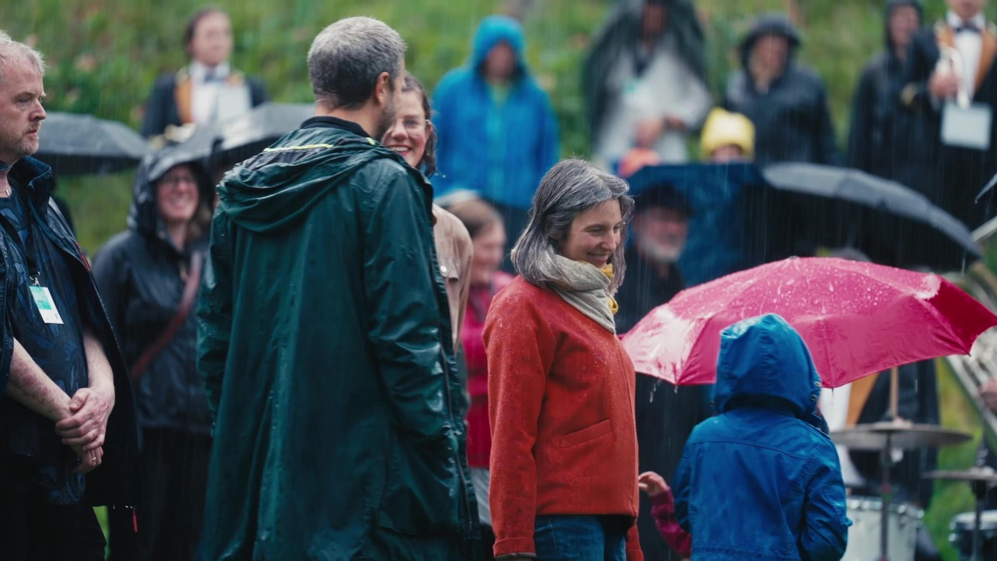 En gruppe mennesker utendørs i regnet